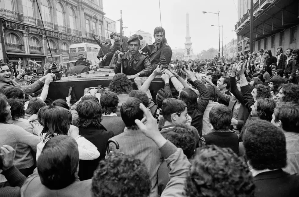 Historic black-and-white street scene with a crowd around a vehicle and soldiers in an urban setting Historic black-and-white street scene with a crowd around a vehicle and soldiers in an urban setting