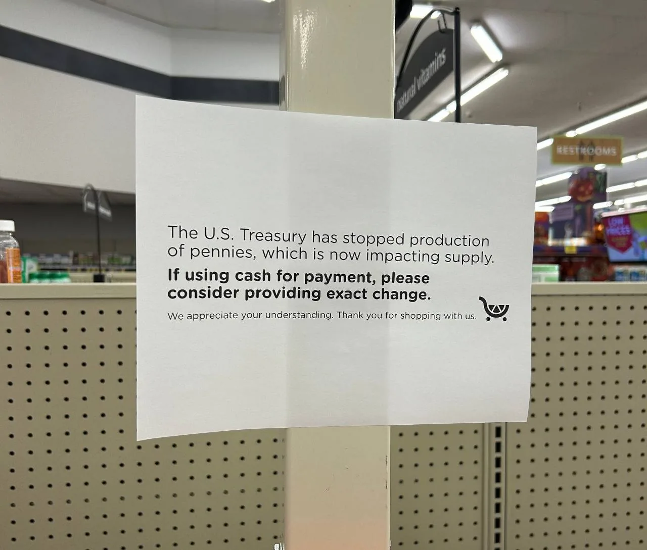 Sign in a U.S. store explaining that penny production has stopped and asking customers to provide exact change