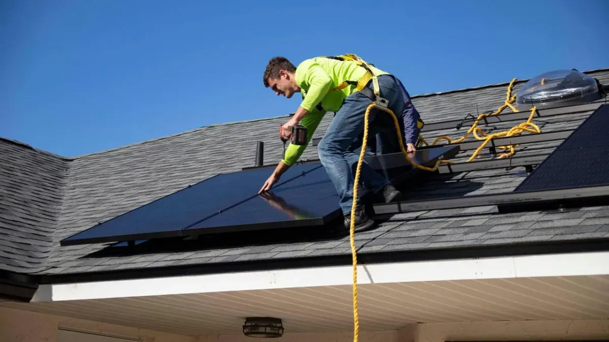 Worker on a roof installing or inspecting solar panels, representing remote professionals with US ties planning where to base themselves